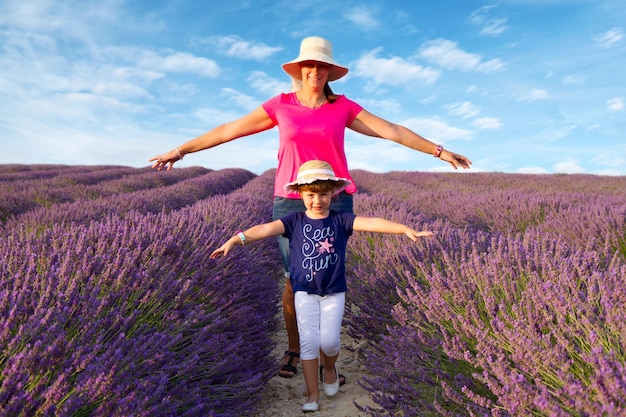 Foto madre y niña caminando en campo de lavanda