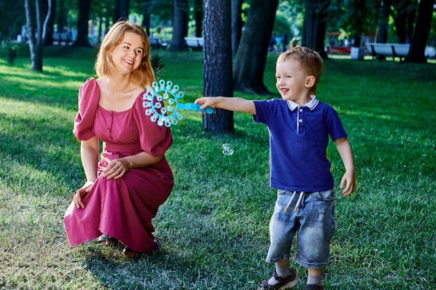 Madre y niño juegan con burbujas afuera