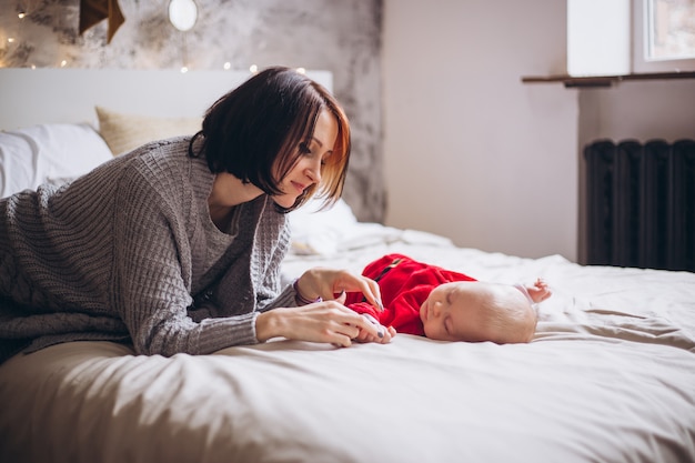 Madre y niño lindo bebé en cama en casa