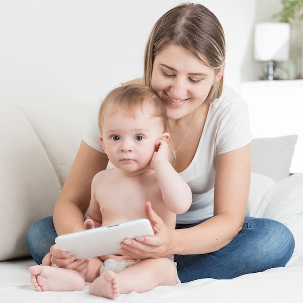 Madre y niño lindo en pañales con tablet pc