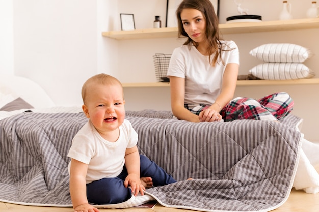 Madre con niño llorando en el dormitorio