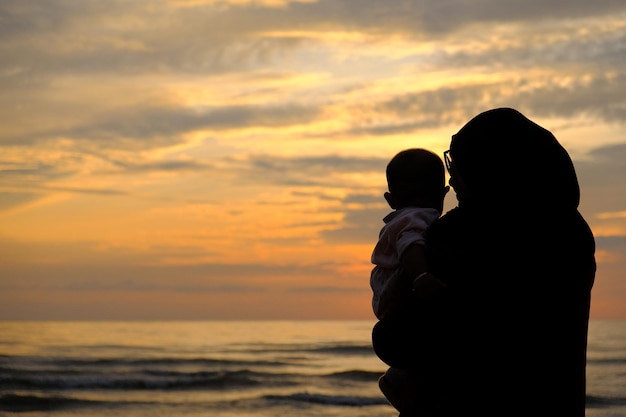 Una madre y un niño mirando la puesta de sol.