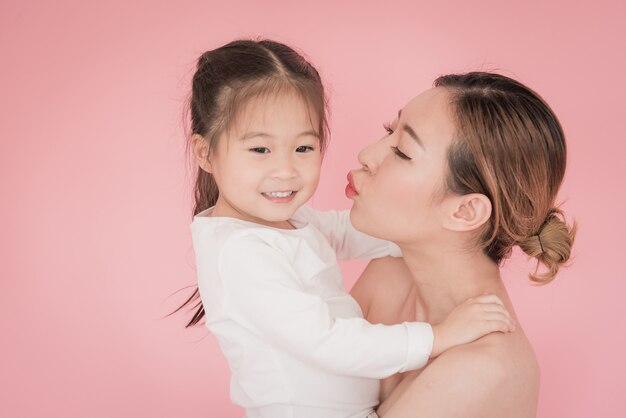 Madre y niño niña besándose con emoción natural sonriendo