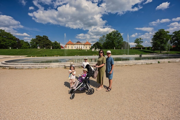 Madre con niños cerca de la fuente del castillo de Slavkov, también conocido como castillo de Austerlitz, es un palacio barroco en Slavkov u Brna, República Checa