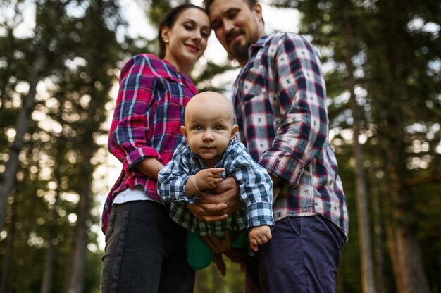 Foto madre, padre y bebé posa en el parque de verano