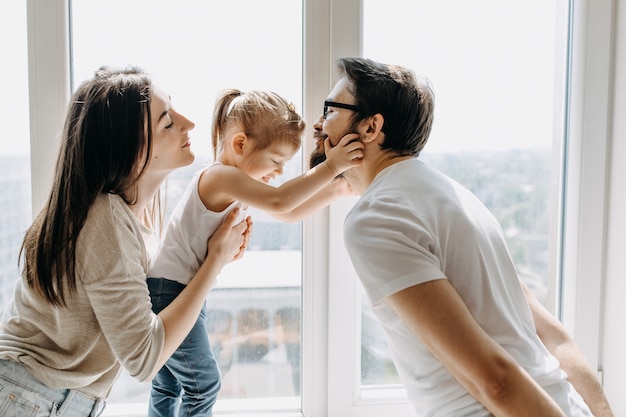 Madre, padre e hija jugando juntos en casa