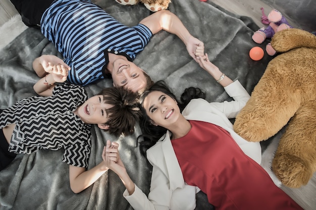 Madre, padre e hijo se divierten en el dormitorio. Concepto de familia feliz.