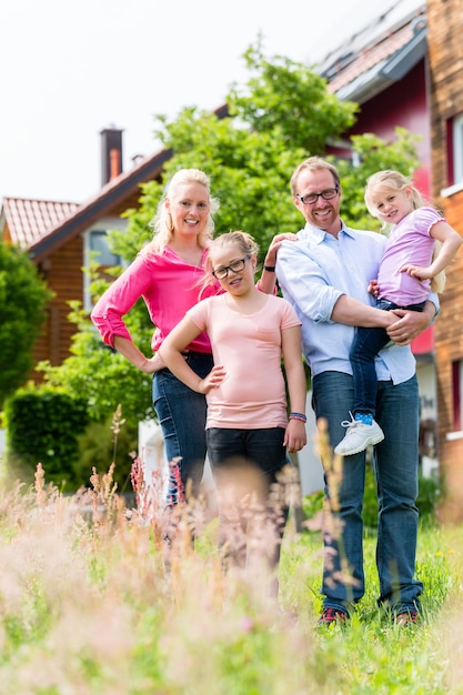 Madre, padre e hijos frente a casa.