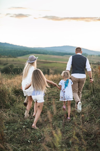 Foto madre y padre jugando con sus hijos hijas en el campo