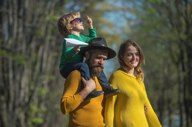 Madre y padre llevando a cuestas a un niño pequeño siéntase libre de aire fresco Familia feliz pasar tiempo libre juntos La libertad es nuestra religión