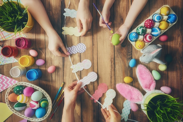 Una madre padre y su hijo pintando huevos Familia feliz preparándose para Pascua