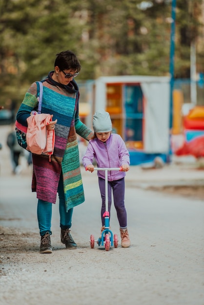 Una madre pasa tiempo en el parque con su hija. Divertido día familiar en el parque para la familia.