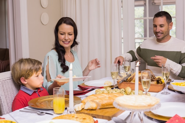 Madre pasando el plato a su hijo