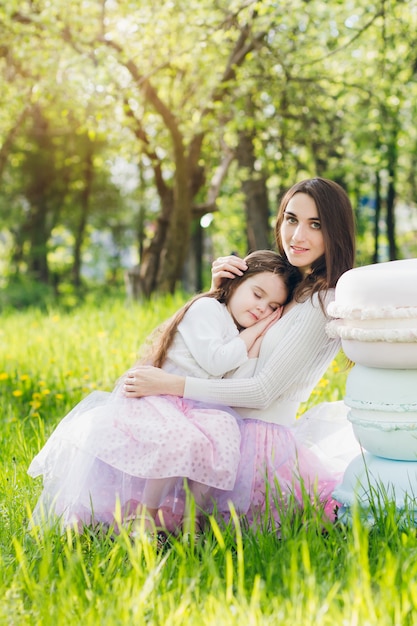 Madre y una pequeña hija caminan en la primavera Apple floreciente