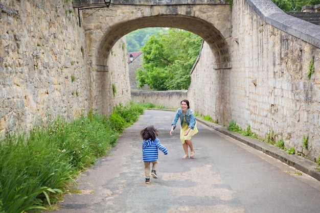 Madre y pequeño y guapo bebé oriental jugando al aire libre en el casco antiguo