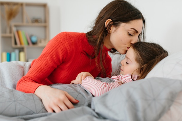 Madre pone a dormir a una pequeña niña.