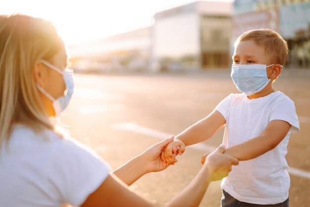 La madre se pone la mascarilla médica de su bebé al atardecer.