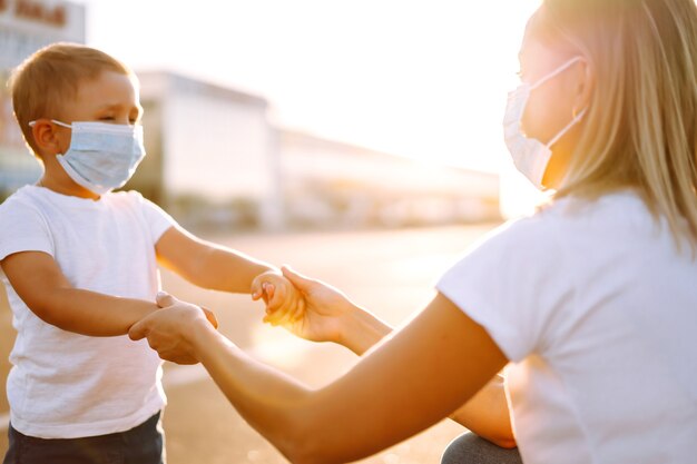 La madre se pone la mascarilla médica de su bebé al atardecer.