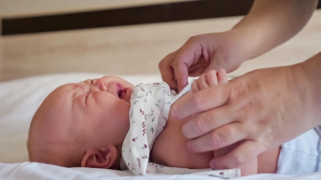 La madre le pone un mono a una niña que llora acostada en la cama