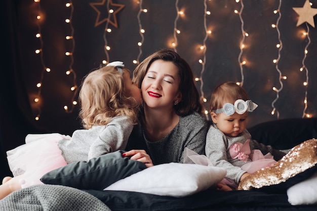 Madre posando a sus dos hijas el día de Navidad