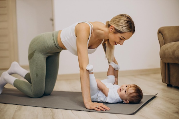 Madre practicando yoga con su hija en casa