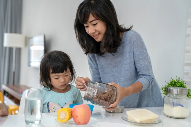 Madre preparando el desayuno para sus hijas