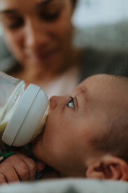 Foto madre de primer plano alimentando al bebé con leche con botella