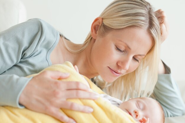 Madre que se relaja al lado de su bebé