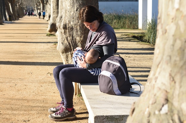 Foto madre en ropa deportiva amamantando a su hijo