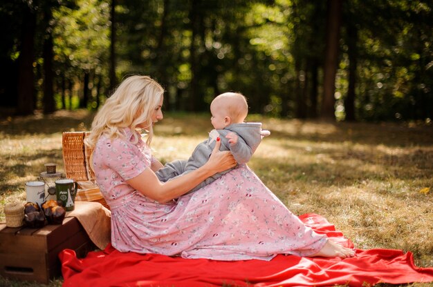 Madre rubia vestida de vestido jugando con bebé