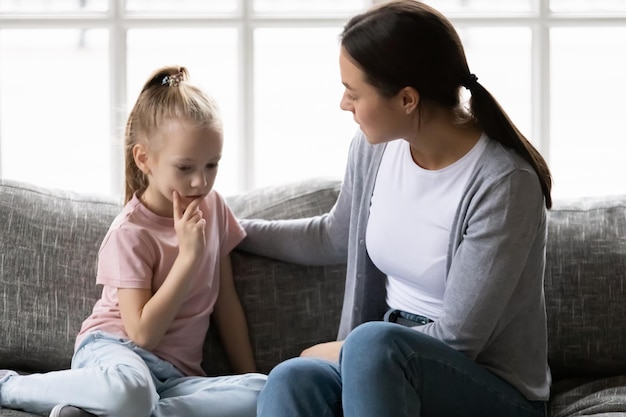 Madre seria hablando con triste molesto preescolar hija niño en casa Mamá consolando chica tranquila dando amor conforto apoyo tocando el hombro del niño en casa psicoterapia concepto de empatía