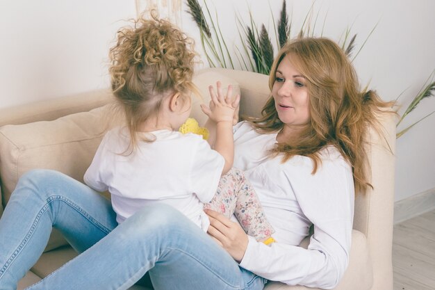 Madre solícita divierte a su hija. Concepto de familia feliz.