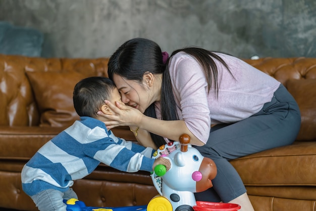 Una madre soltera asiática con su hijo está jugando con un juguete juntos cuando vive en una casa tipo loft para el autoaprendizaje