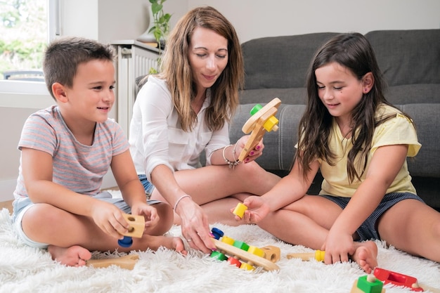 Foto madre soltera jugando con sus hijos en casa