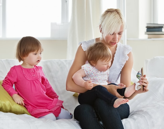 Madre sonriente jugando con sus hijas