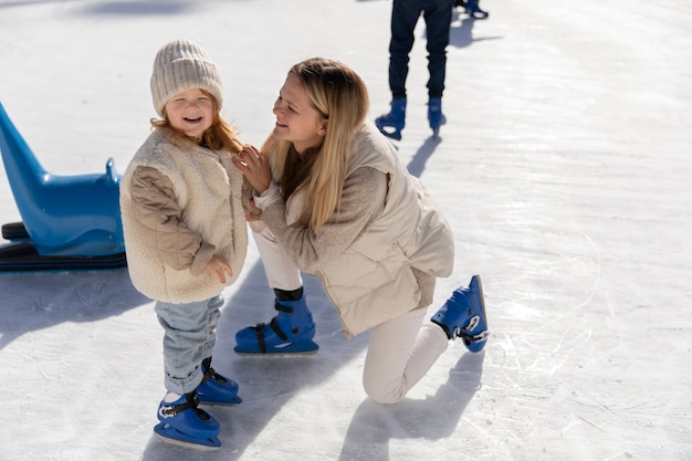 Foto madre sonriente de tiro completo y niña en la pista