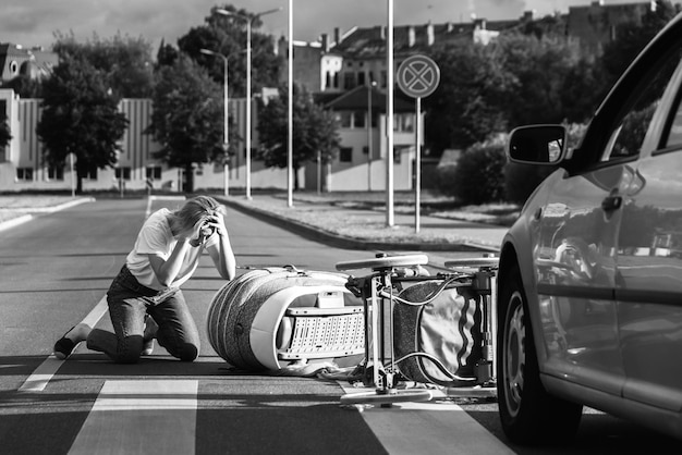 Foto madre sorprendida en el cruce de peatones después de un accidente automovilístico cuando un vehículo golpea su cochecito de bebé