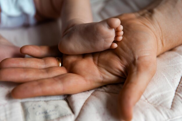 Foto madre sosteniendo una mano de un bebé recién nacido