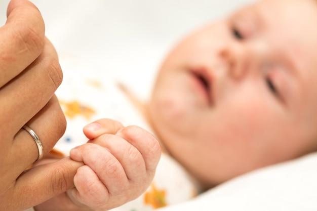 Madre sosteniendo la mano de un bebé en su mano