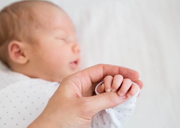 Madre sosteniendo una pequeña mano de un bebé recién nacido