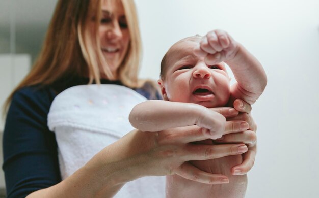 Foto madre sosteniendo a su hijo mojado en el baño