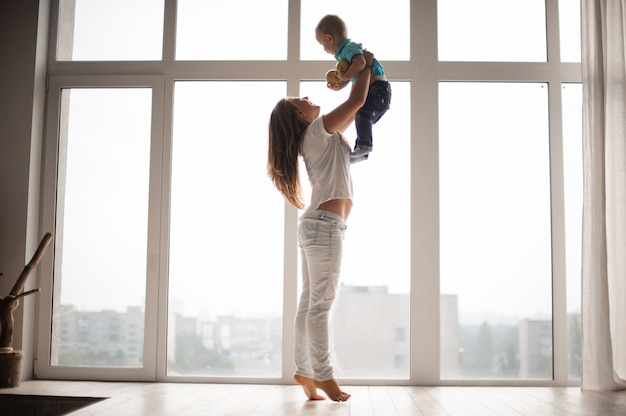 Madre sosteniendo a su niño en el aire