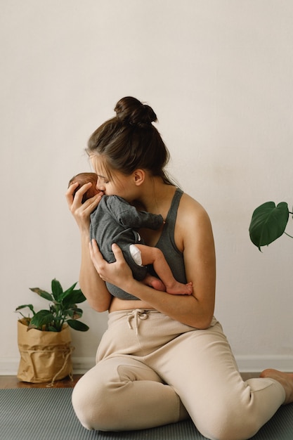 Foto la madre sostiene y abraza a su hijo recién nacido en casa mamá y bebé feliz