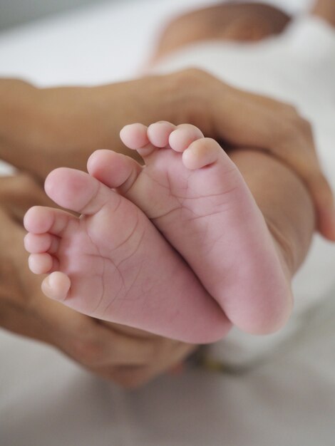 La madre sostiene el pie del bebé recién nacido, ternura