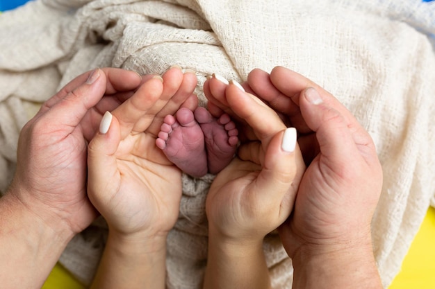 Una madre sostiene los pies de un bebé con la palabra bebé.