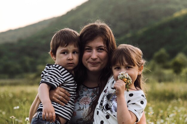 La madre sostiene a su hijo e hija en sus brazos y los ama mucho alegría de la maternidad