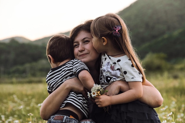 La madre sostiene a su hijo e hija en sus brazos y los ama mucho