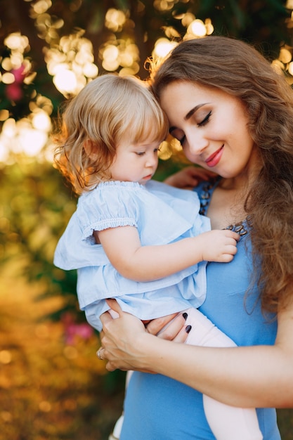 La madre sostiene suavemente a la pequeña hija en sus brazos.