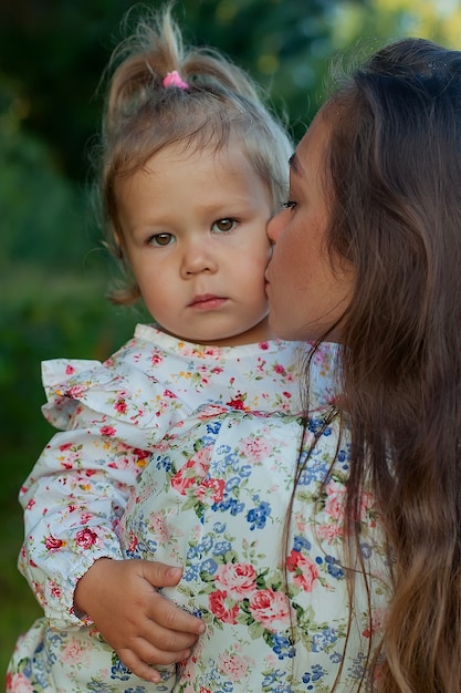 La madre sostiene suavemente a su hija en sus brazos y la besa