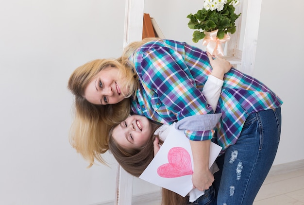 La madre sostiene la tarjeta de felicitación de su hermosa hija